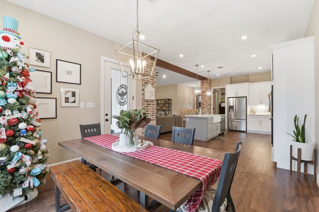 a kitchen with a refrigerator and wooden floor