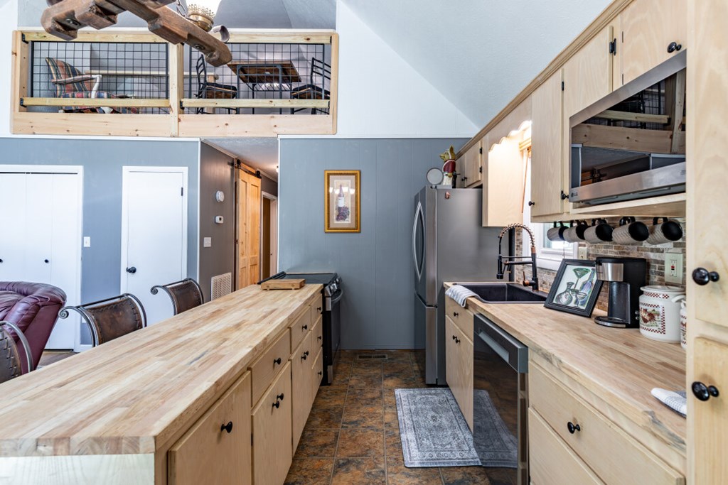 411 Piney Acres Road Blue Ridge, GA 30513 - Photo 15 of 72 a kitchen with stainless steel appliances granite countertop a stove a sink and a refrigerator