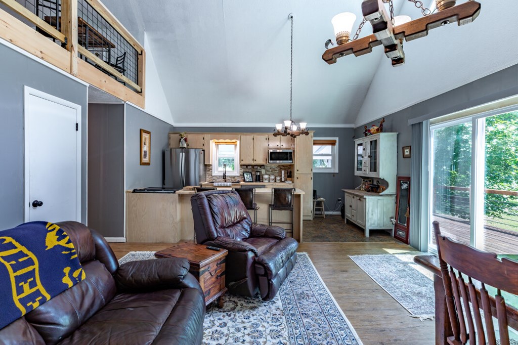 411 Piney Acres Road Blue Ridge, GA 30513 - Photo 22 of 72 a living room with furniture and a chandelier