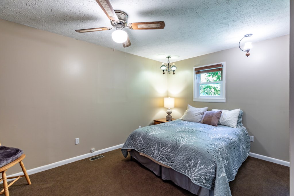 411 Piney Acres Road Blue Ridge, GA 30513 - Photo 26 of 72 a bedroom with a bed ceiling fan and window