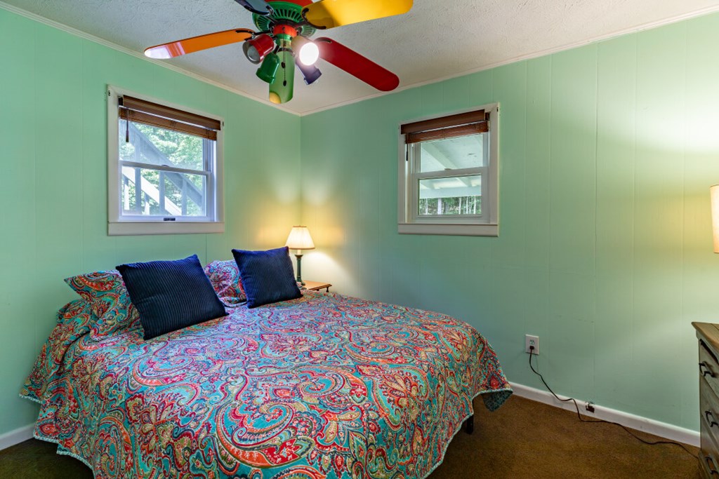 411 Piney Acres Road Blue Ridge, GA 30513 - Photo 29 of 72 a bedroom with a bed and a painting on the wall