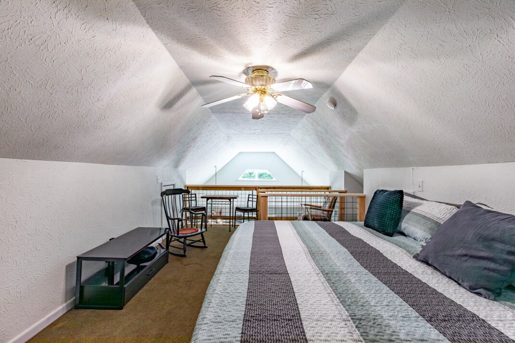 411 Piney Acres Road Blue Ridge, GA 30513 - Photo 44 of 72 a bedroom with a bed and a chandelier