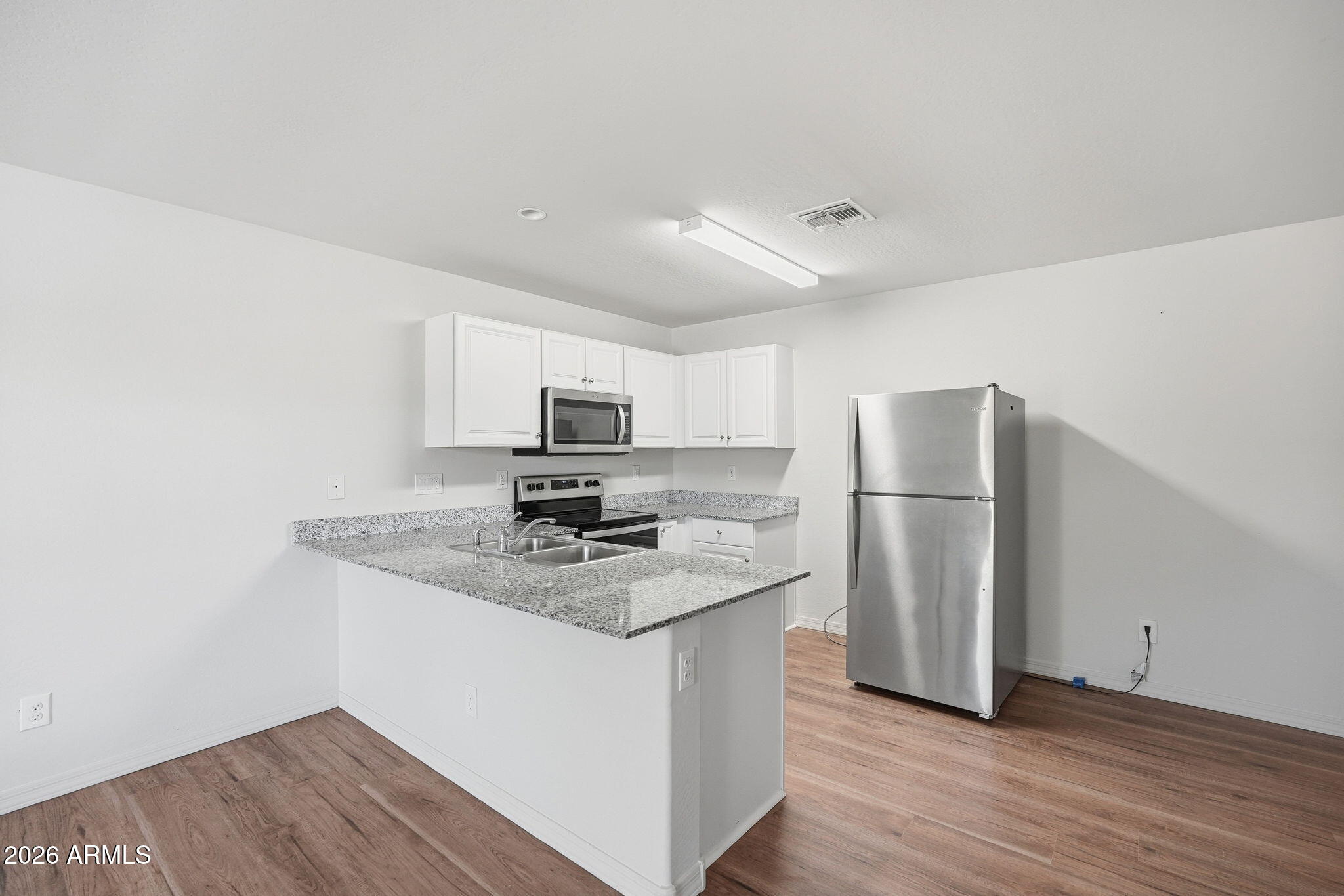 135 Watson Place Casa Grande, AZ 85122 - Photo 9 of 24 a kitchen with stainless steel appliances granite countertop a refrigerator a sink a stove a microwave and island