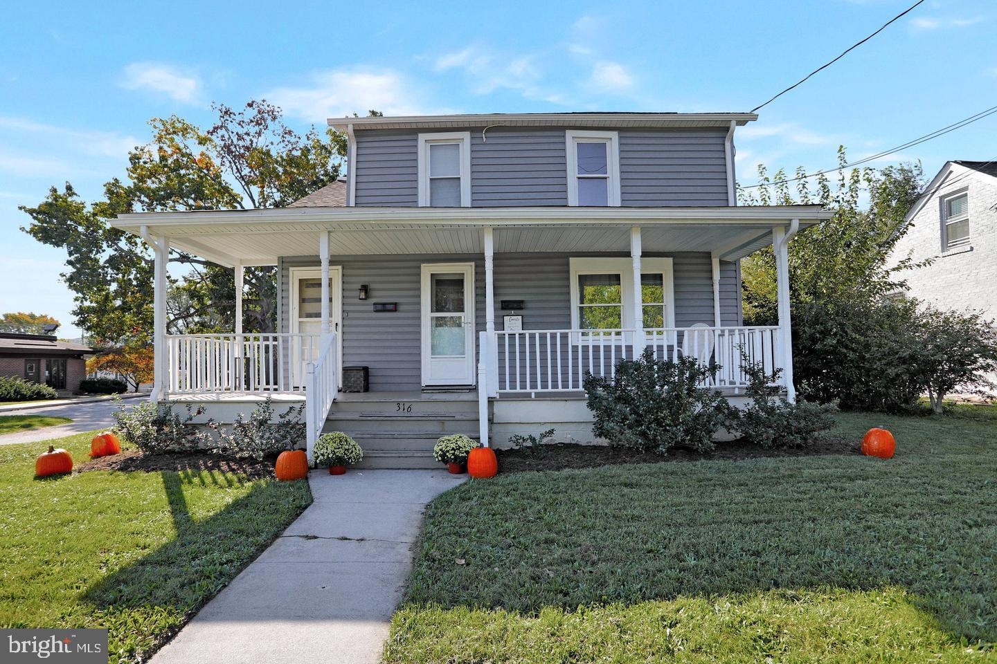 a front view of a house with a yard and potted plants