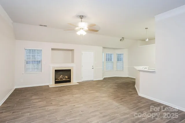 a view of empty room with wooden floor and fireplace