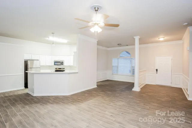 a view of a kitchen with wooden floor and a ceiling fan