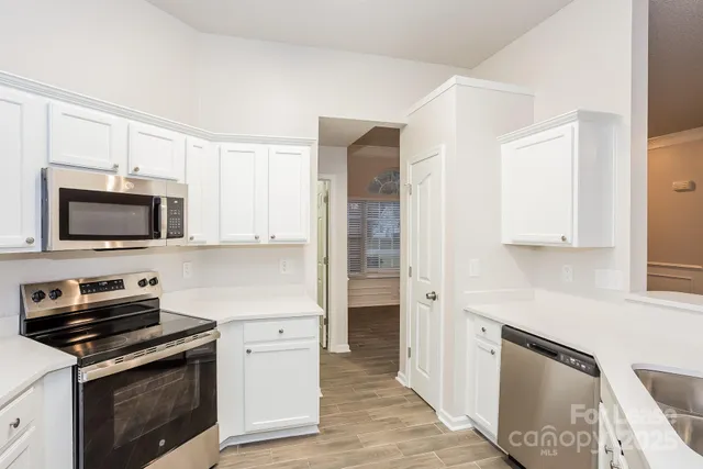 a kitchen with white cabinets and stainless steel appliances