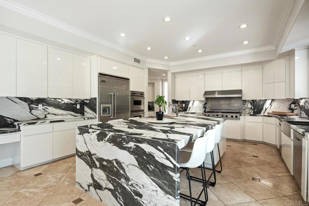6773 Poco Lago Rancho Santa Fe, CA 92067 - Photo 23 of 65 a kitchen with stainless steel appliances granite countertop a stove top oven a sink a stove a dining table and chairs
