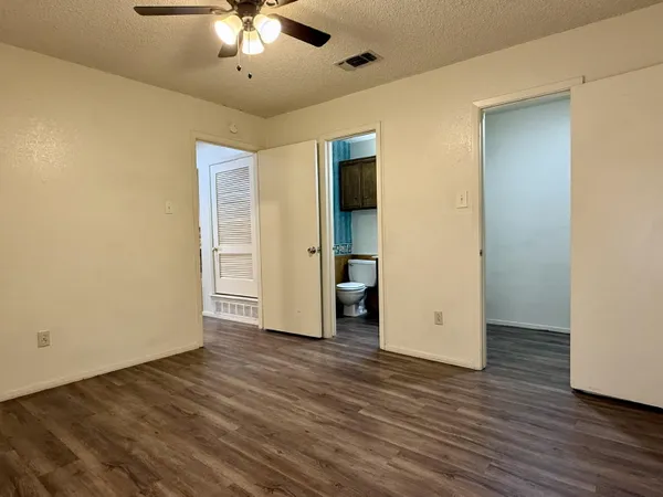 an empty room with wooden floor chandelier and closet