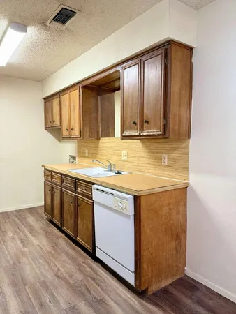 a kitchen with stainless steel appliances granite countertop wooden cabinets and a sink