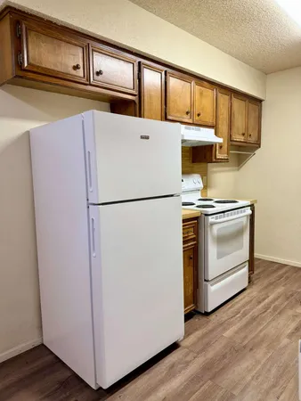 a white refrigerator freezer and a wooden floor