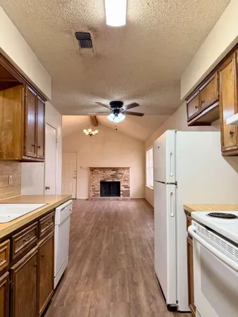 a view of open kitchen with a sink refrigerator and window
