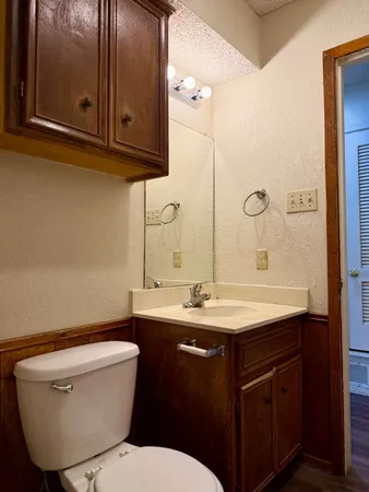 a bathroom with a toilet sink and mirror