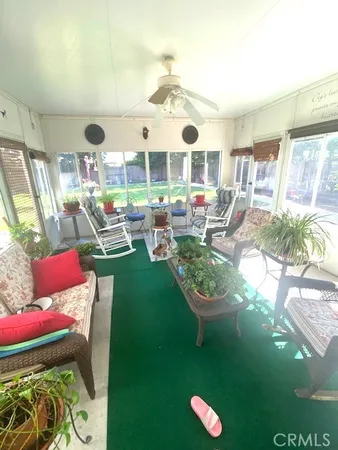 a room with lots of white furniture and a large window