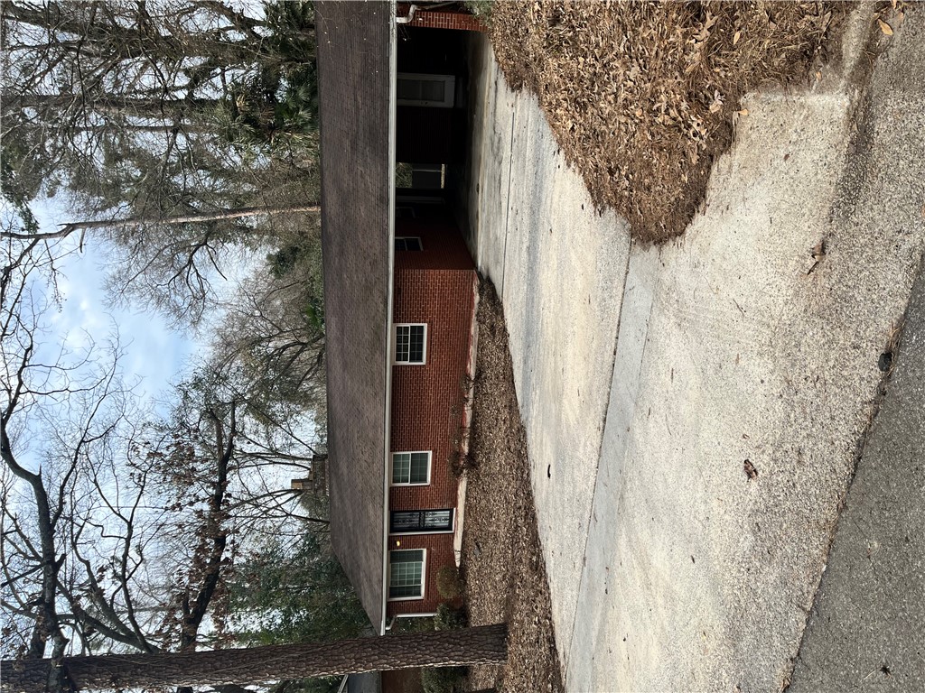 207 Pine Lane Anderson, SC 29621 - Photo 2 of 13 Brick residence with a well-maintained driveway, surrounded by mature trees.