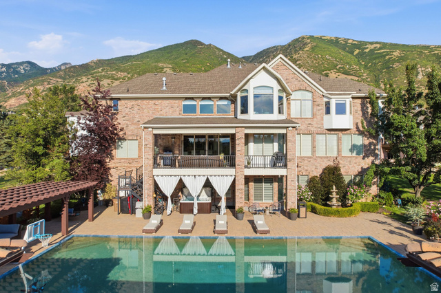 12308 Mariah Circle Draper, UT 84020 - Photo 131 of 293 Brick exterior residence with a multi-level deck overlooking a swimming pool and mountains