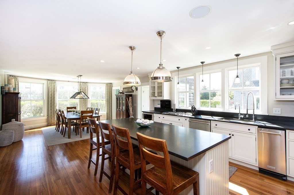 17 Gannett Road Scituate, MA 02066 - Photo 13 of 36 a kitchen with stainless steel appliances granite countertop a table chairs stove and wooden floor
