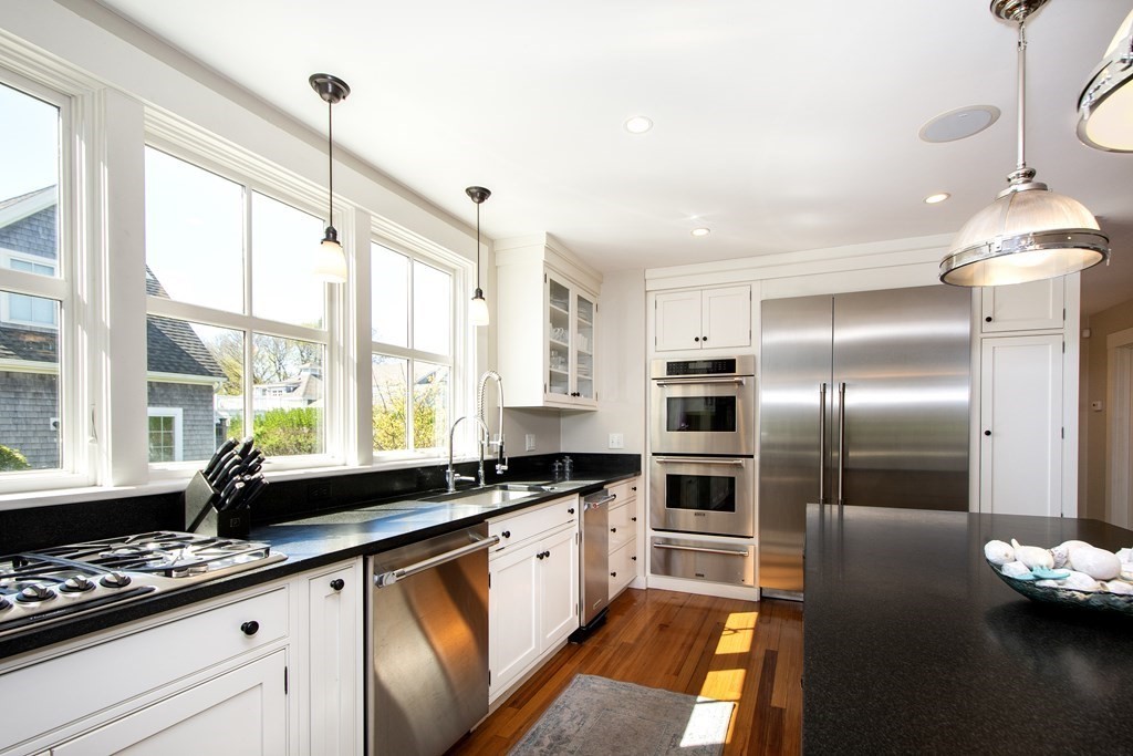17 Gannett Road Scituate, MA 02066 - Photo 14 of 36 a kitchen with stainless steel appliances kitchen island granite countertop a sink and cabinets