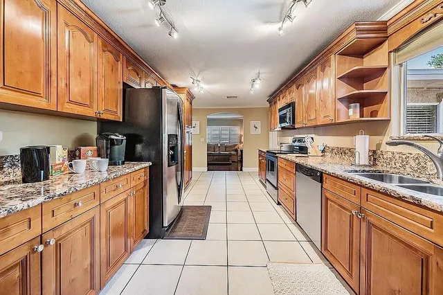 a bathroom with a granite countertop sink a toilet a mirror a bathtub and shower