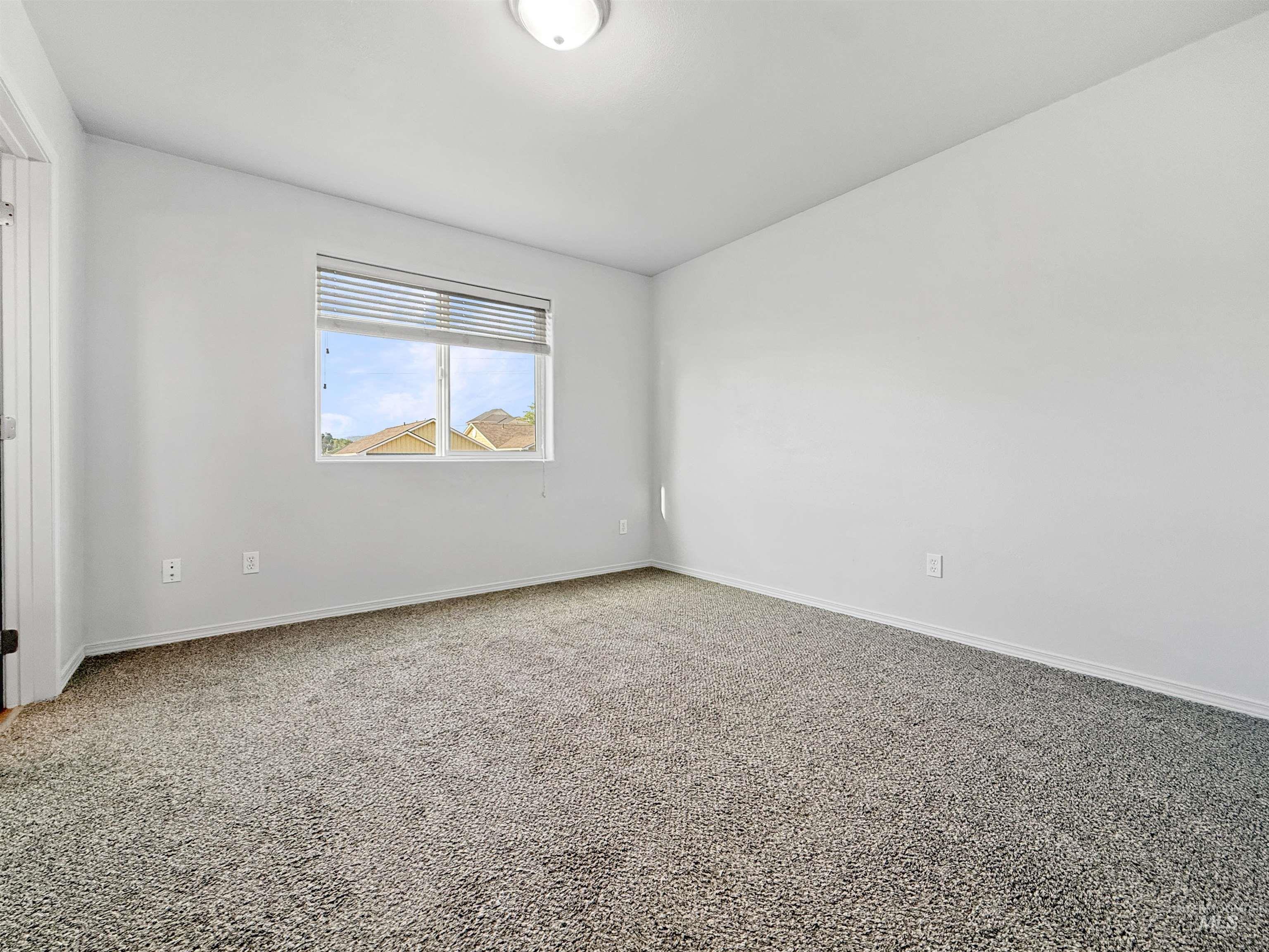 1354 Bristol Road Moscow, ID 83843 - Photo 9 of 19 Carpeted room featuring a double-paned window with blinds, white walls, and a flush mount ceiling light