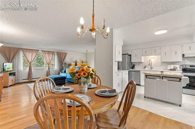 a view of a dining room with furniture a chandelier and wooden floor