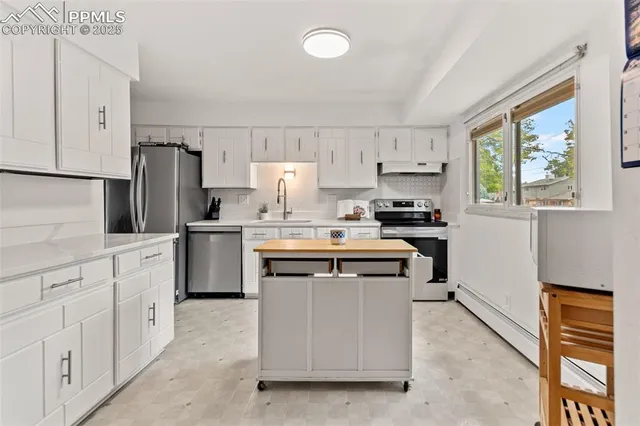 a kitchen with stainless steel appliances a sink stove refrigerator and cabinets