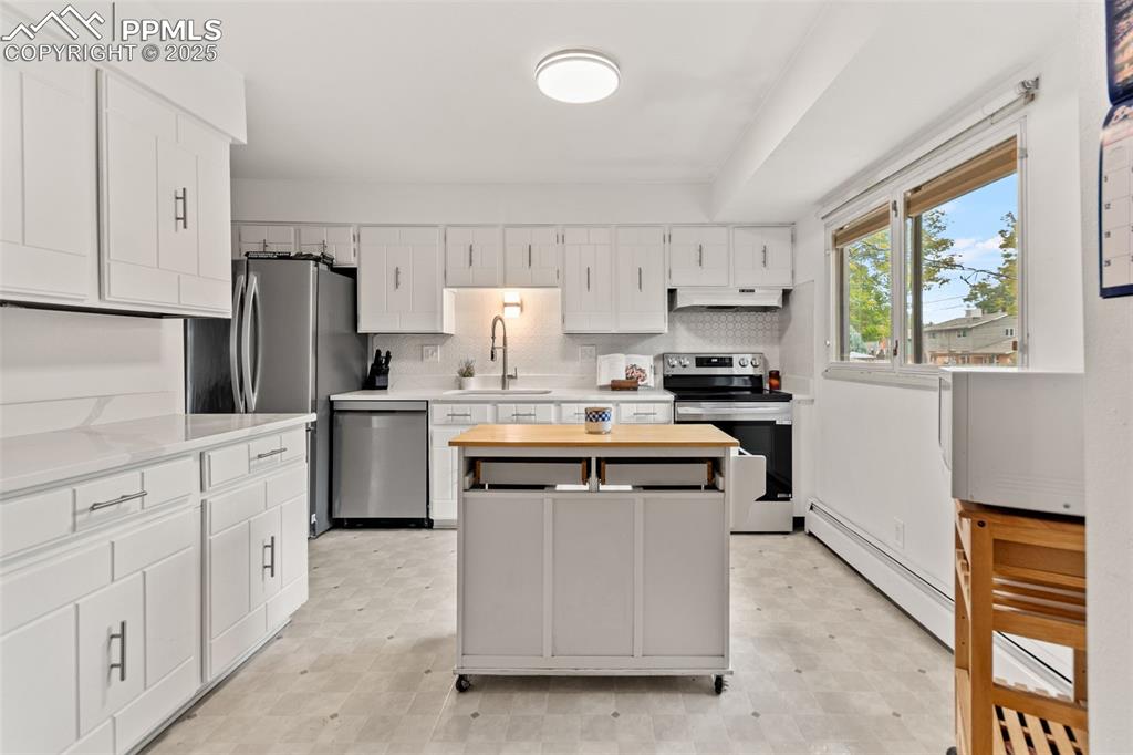 2801 South Reed Street Denver, CO 80227 - Photo 13 of 44 a kitchen with stainless steel appliances a sink stove refrigerator and cabinets