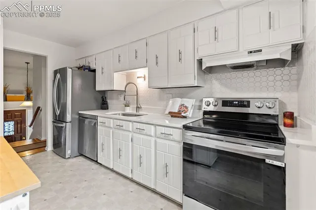 a kitchen with stainless steel appliances white cabinets and a sink