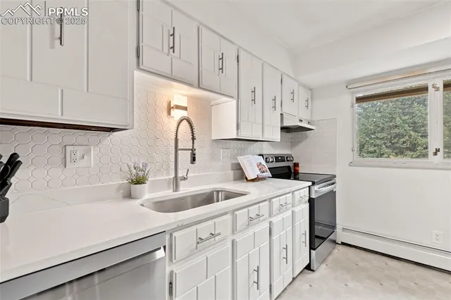 a kitchen with white cabinets and white appliances