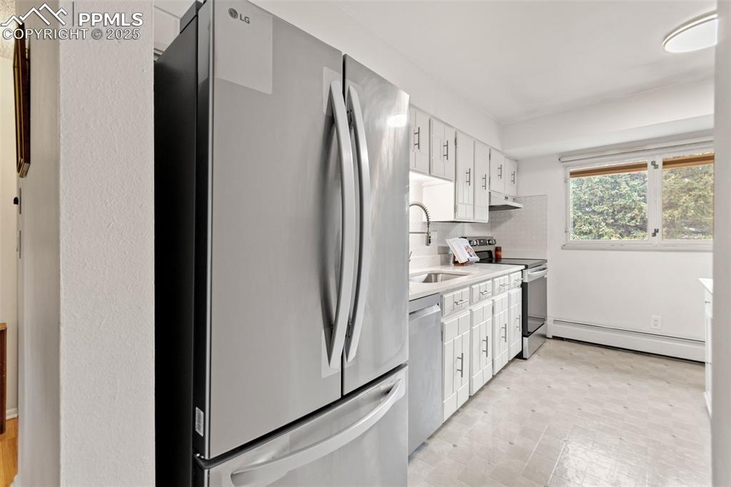 2801 South Reed Street Denver, CO 80227 - Photo 19 of 44 a kitchen with white cabinets and white appliances