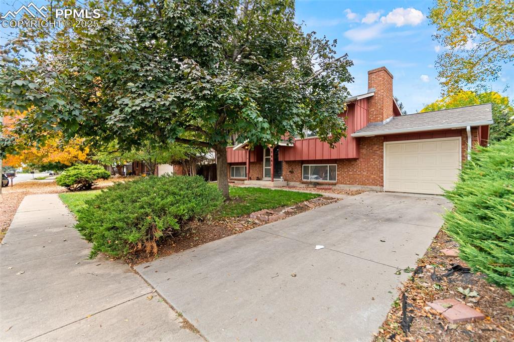 2801 South Reed Street Denver, CO 80227 - Photo 4 of 44 a front view of a house with a yard and a garage