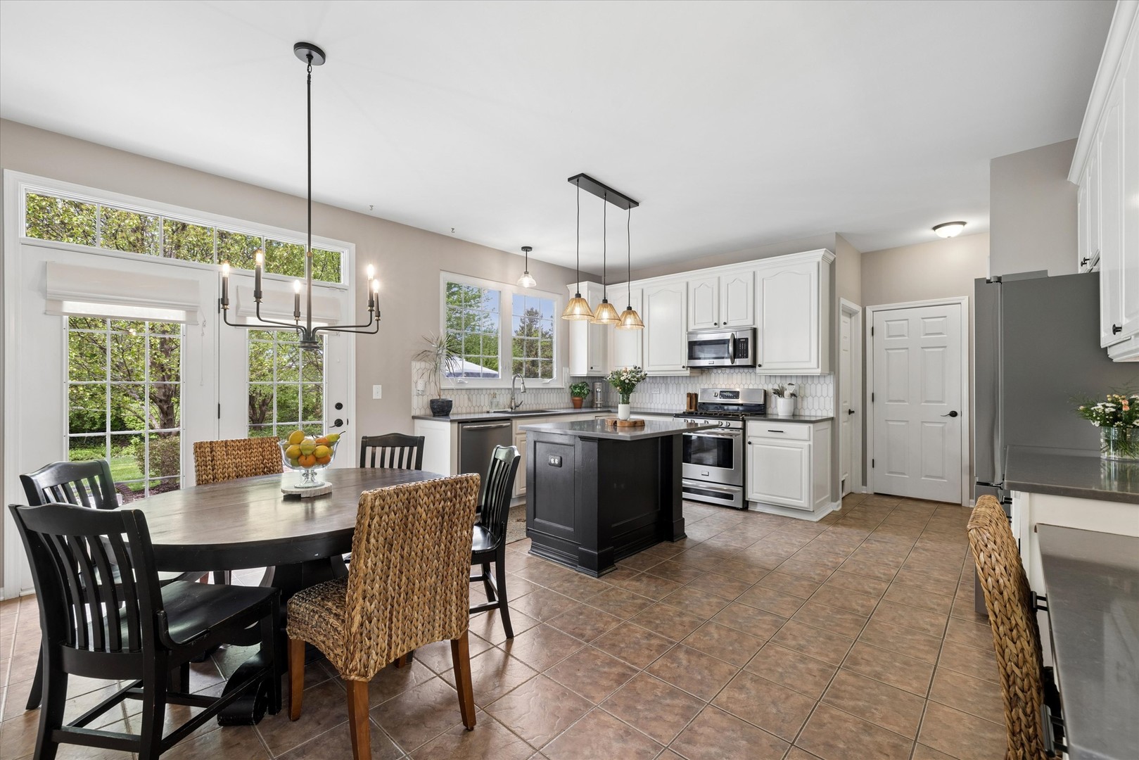 340 Tenby Way Algonquin, IL 60102 - Photo 7 of 36 a kitchen with kitchen island a dining table chairs stainless steel appliances and cabinets