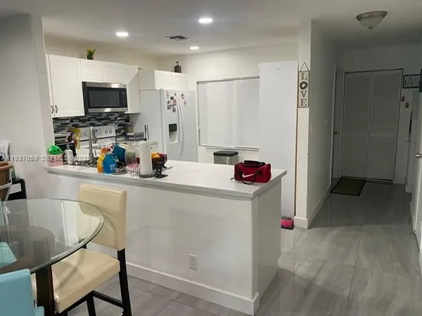 a kitchen with a refrigerator and a sink