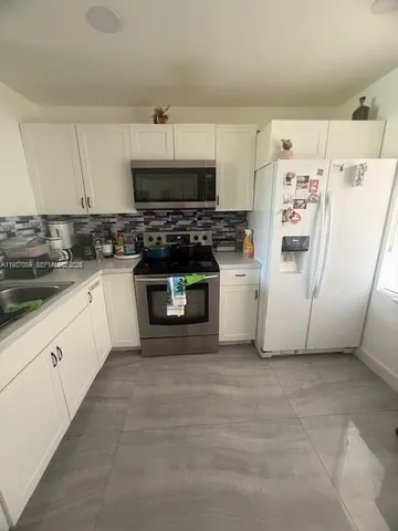 a kitchen with stainless steel appliances a refrigerator sink and cabinets