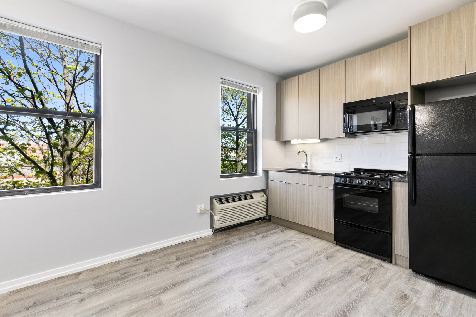 4875 North Magnolia Avenue, Unit 415 Chicago, IL 60640 - Photo 2 of 7 a kitchen with white cabinets and stainless steel appliances