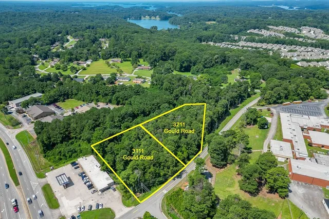 an aerial view of residential houses with outdoor space and trees