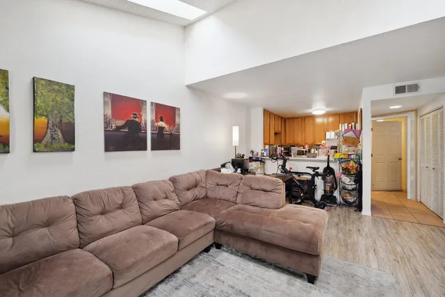a living room with furniture kitchen area and a couch