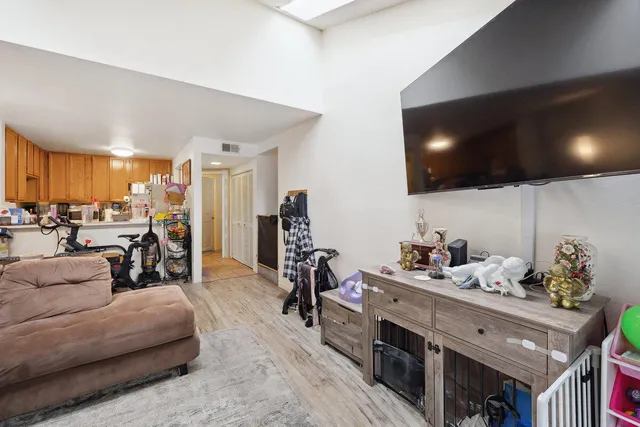 a living room with furniture kitchen and a flat screen tv
