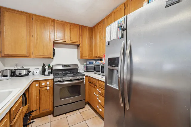 a kitchen with stainless steel appliances granite countertop a refrigerator a stove a sink and dishwasher