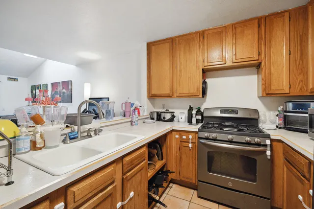 a kitchen with granite countertop a sink stainless steel appliances wooden cabinets and a counter top space