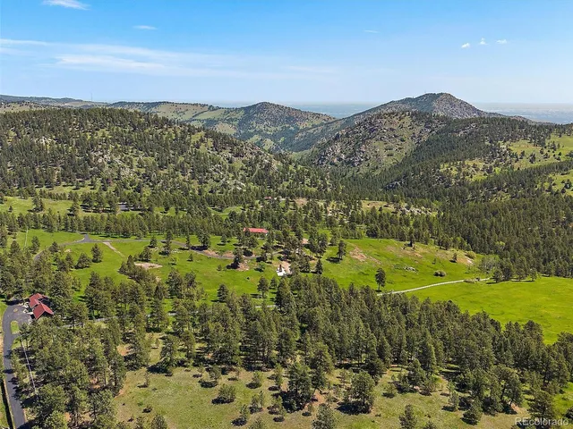 a kitchen with stainless steel appliances granite countertop a refrigerator a sink dishwasher a dining table and chairs with wooden floor