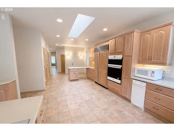 a open kitchen with stainless steel appliances kitchen island granite countertop a refrigerator and a sink