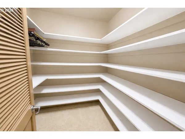 a view of walk in closet with empty racks
