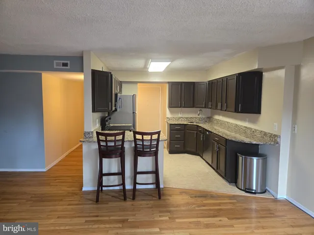 a kitchen with stainless steel appliances granite countertop a refrigerator stove microwave and sink