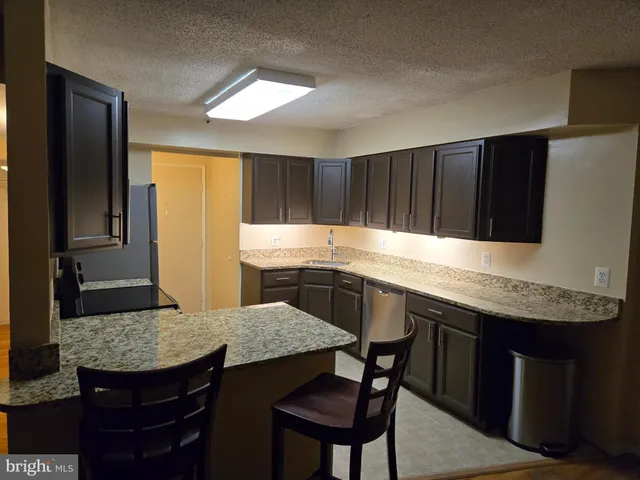 a kitchen with granite countertop kitchen island stainless steel appliances a sink table and chairs