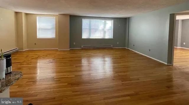 a view of empty room with window and wooden floor