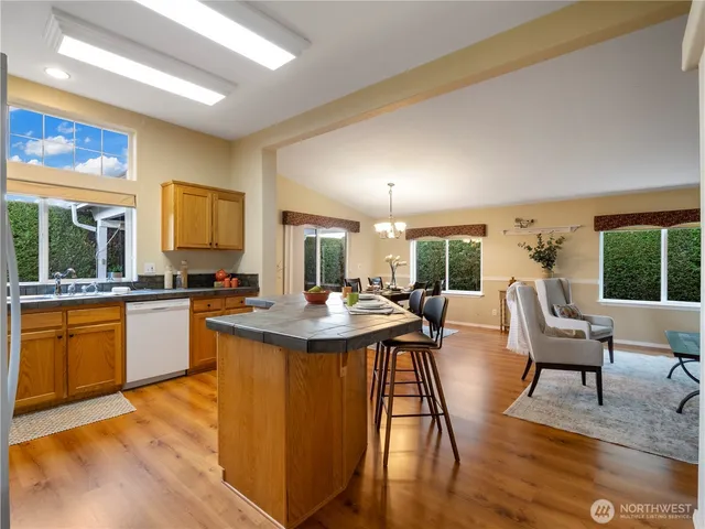 a dining hall with stainless steel appliances granite countertop a dining table and chairs with wooden floor