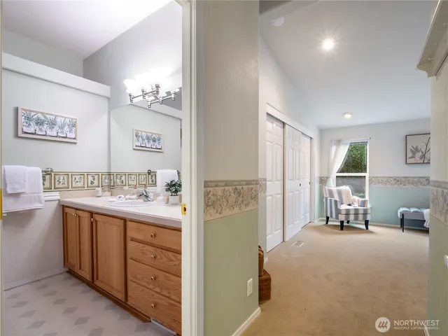 a view of a hallway with bathroom and mirror