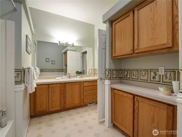 a spacious bathroom with a granite countertop sink and a mirror