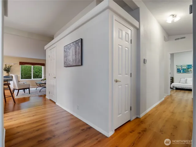 a view of a hallway to a livingroom with furniture and windows